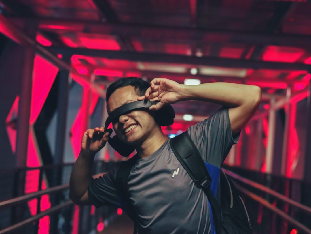 man standing while holding black headphones