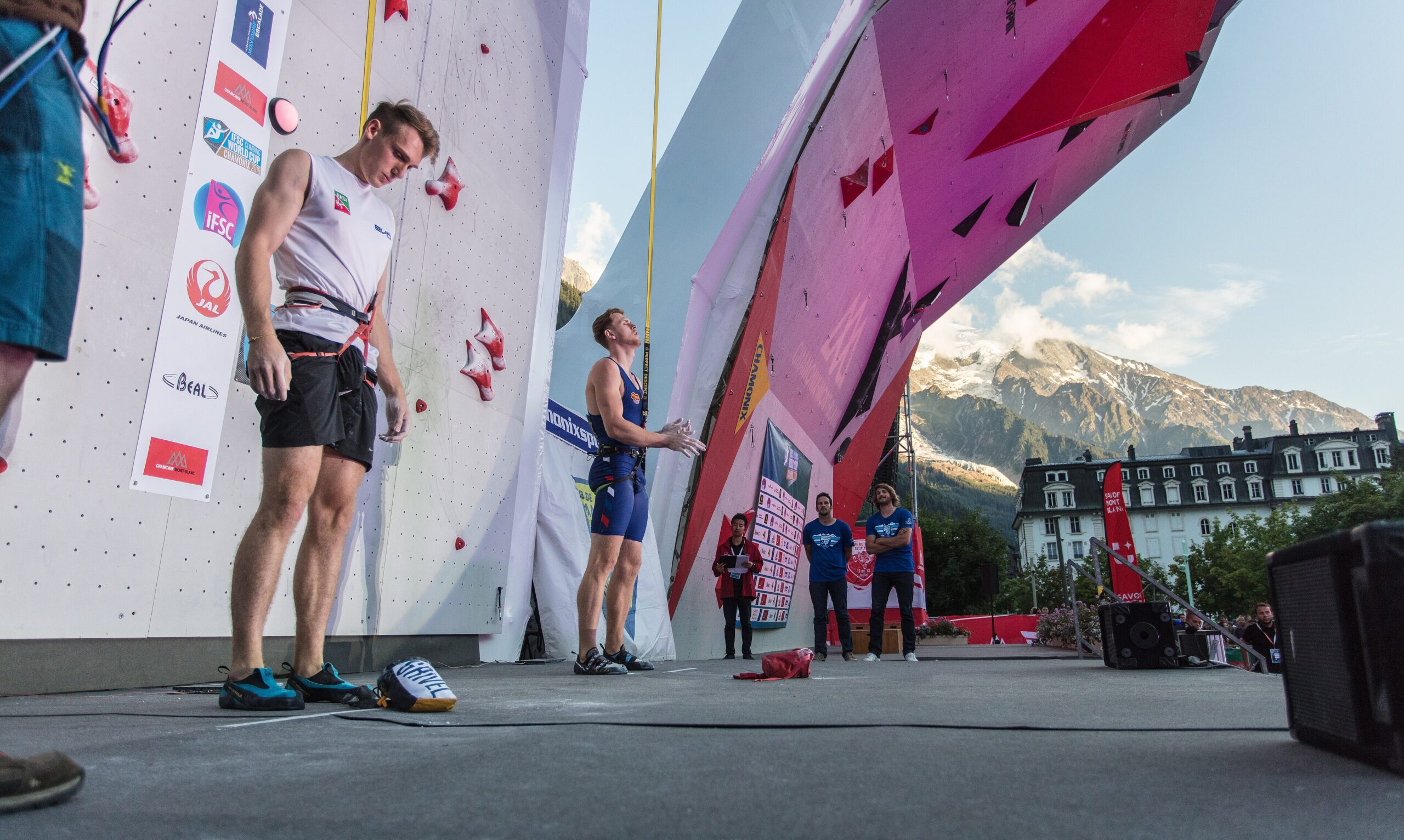 Dua atlet panjat tebing speed bersiap di dinding kompetisi IFSC Climbing World Cup Chamonix dengan latar Pegunungan Alpen