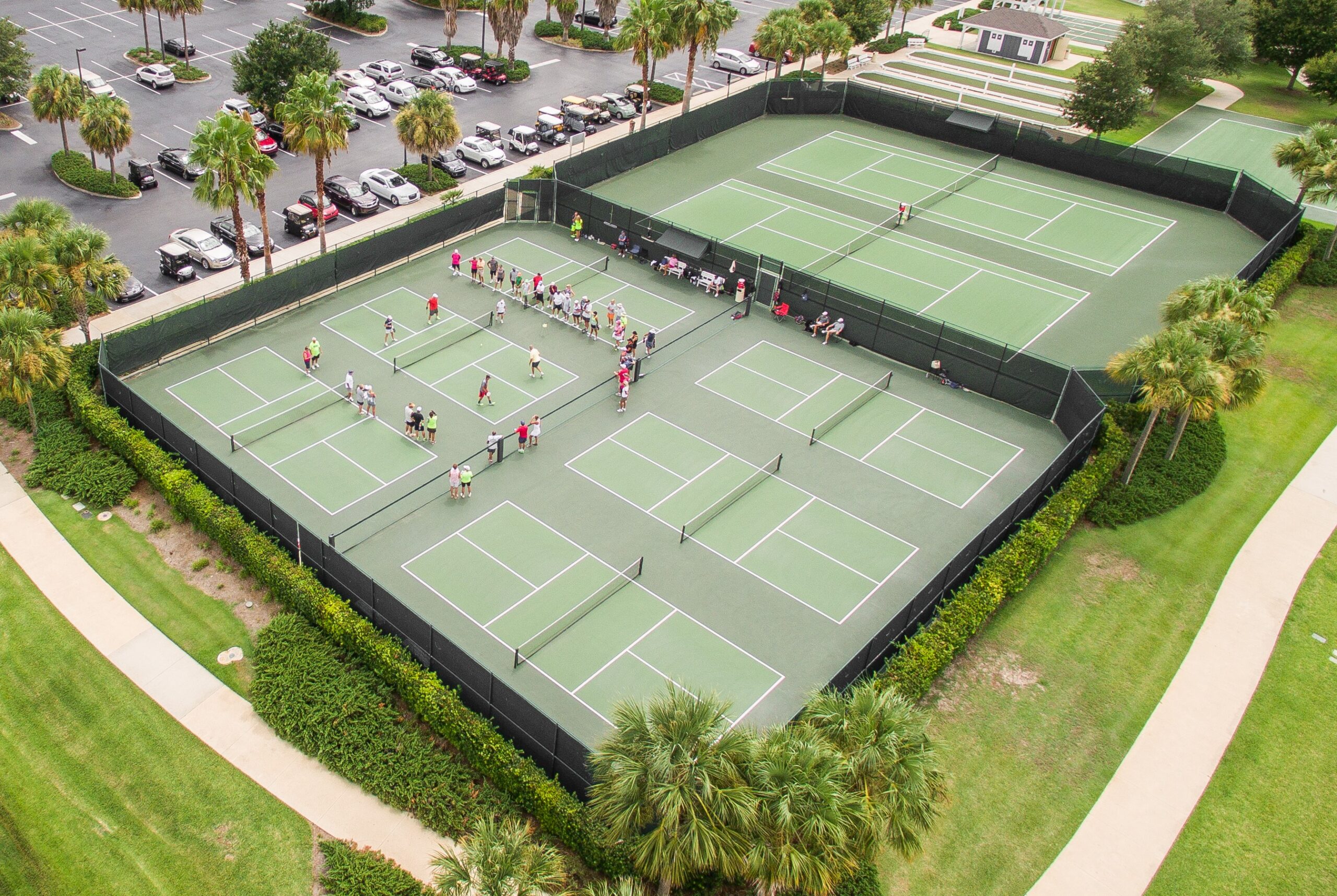 Foto udara kompleks lapangan pickleball dengan garis-garis khas dan banyak pemain di setiap lapangan.