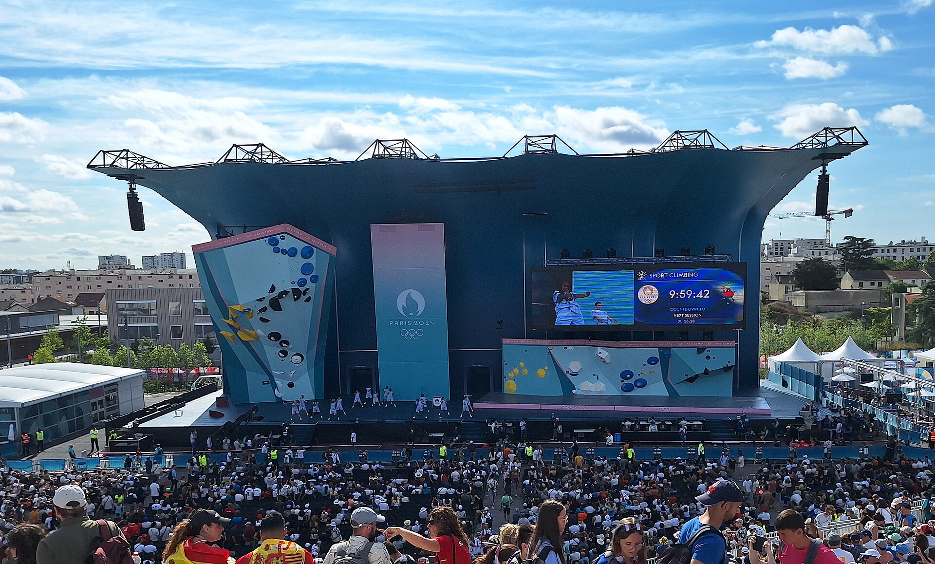 Foto ilustrasi arena panjat tebing Olimpiade Paris 2024 di Le Bourget yang dipadati penonton, dengan dinding panjat dan layar besar bertuliskan Sport Climbing