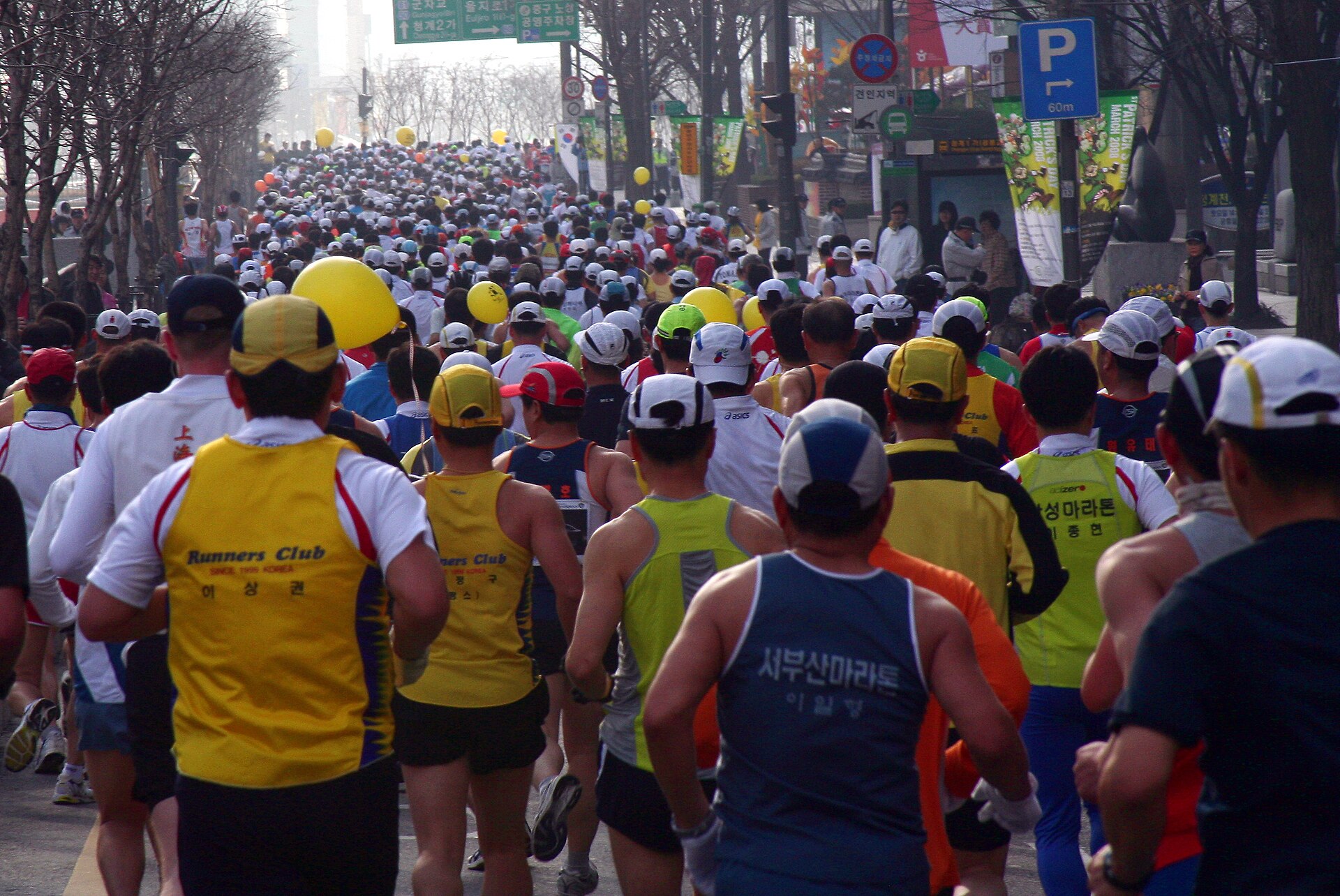 Ribuan pelari maraton berlari di jalan kota yang berkabut tipis, tampak dari belakang, foto ilustrasi Seoul International Marathon 2008